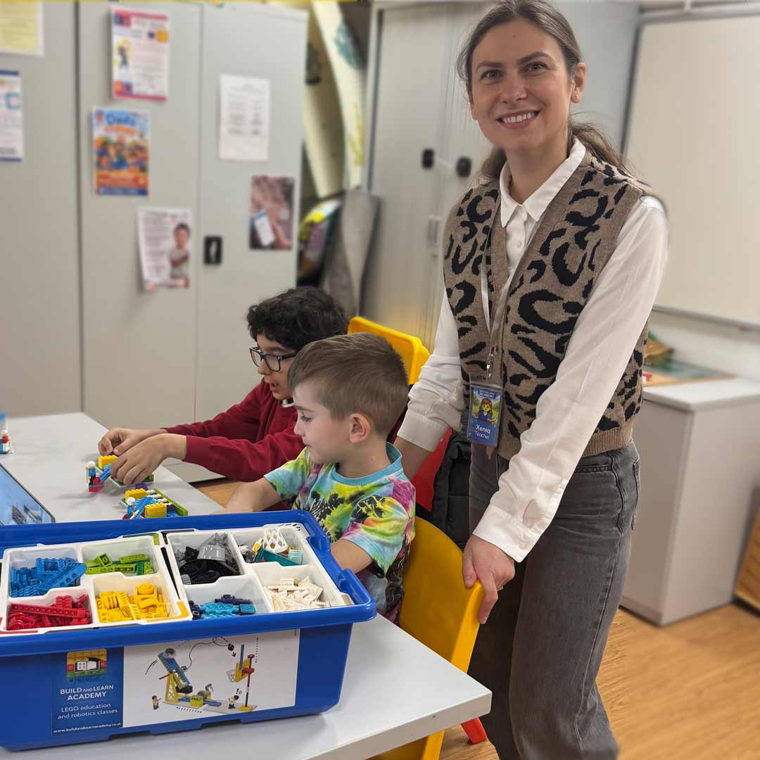 A facilitator supporting children during a building session.